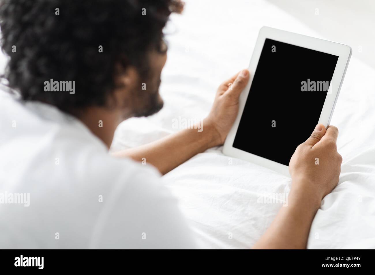 Dark-skinned man using digital tablet with blank screen Stock Photo