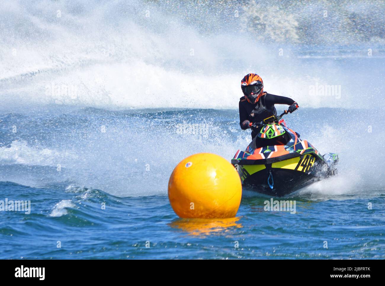 Jet Ski competitor cornering at speed creating at lot of spray. Stock Photo