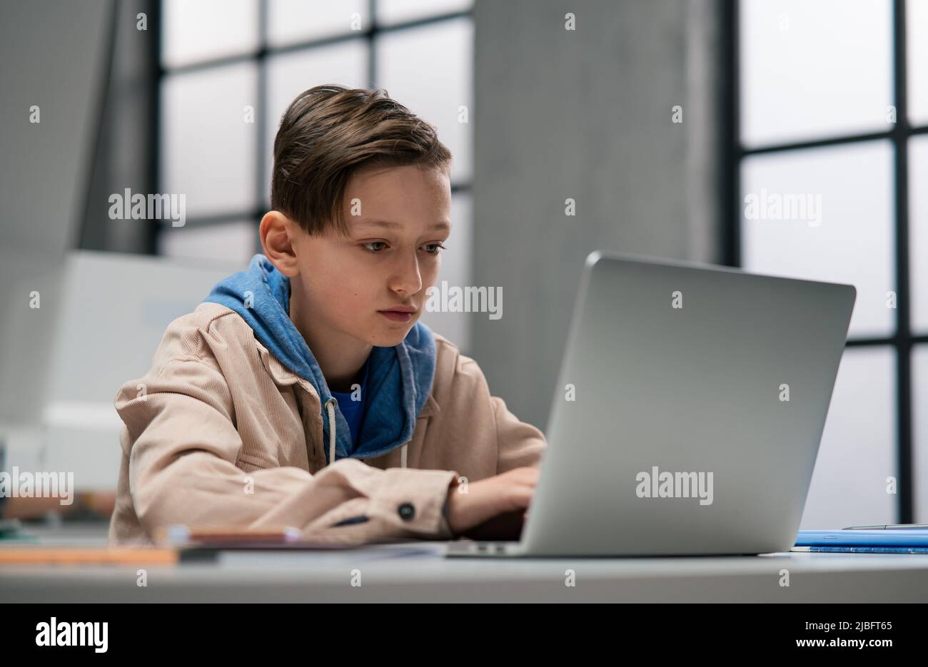 A schoolboy using computer in classroom at school Stock Photo - Alamy