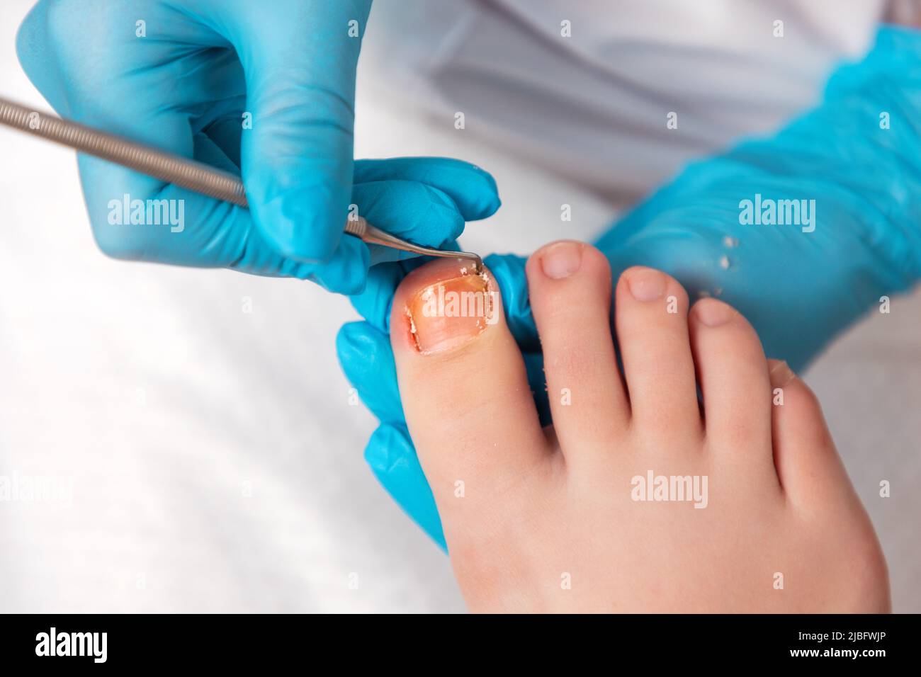 A pedicurist does a pedicure for the client's feet, cleaning the nails ...