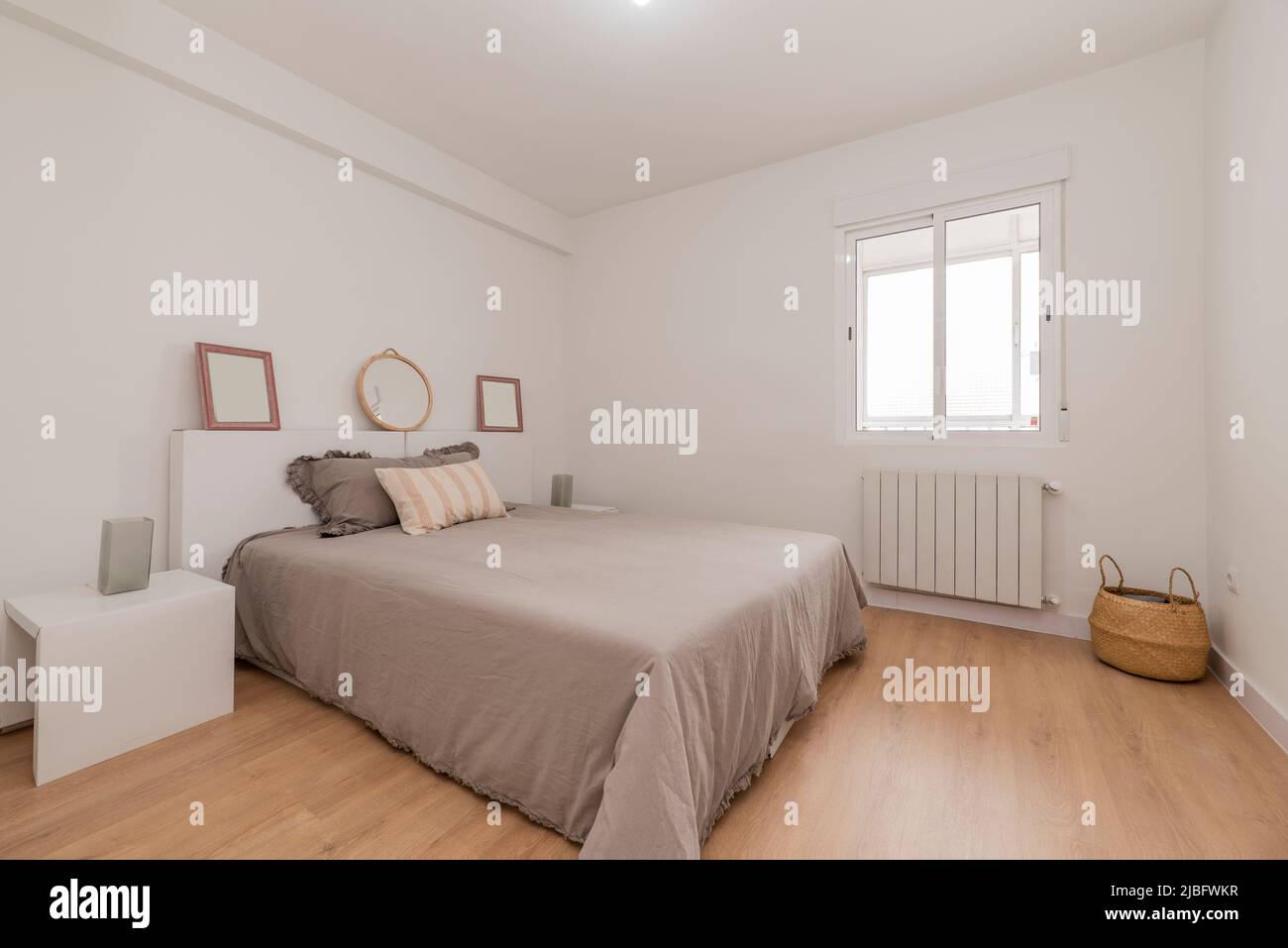 Double bedroom with bed with quilt, white headboard with matching side