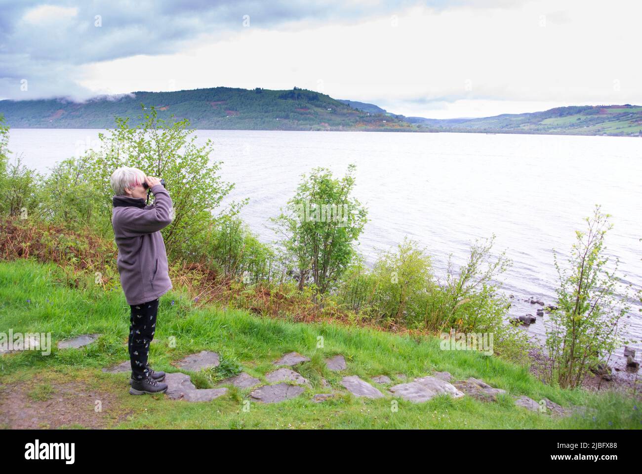 Loch Ness, woman, birdwatching, binoculars Stock Photo