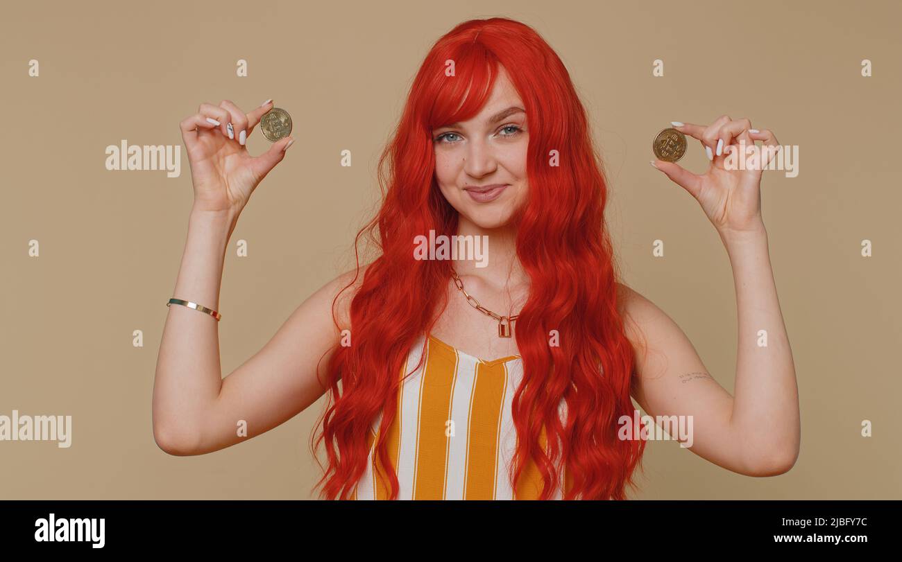 Redhead woman winner showing golden bitcoins. Career wealth cryptocurrency  investment mining future technology. Young ginger girl fooling making  faces. Happy businesswoman isolated on beige background Stock Photo - Alamy