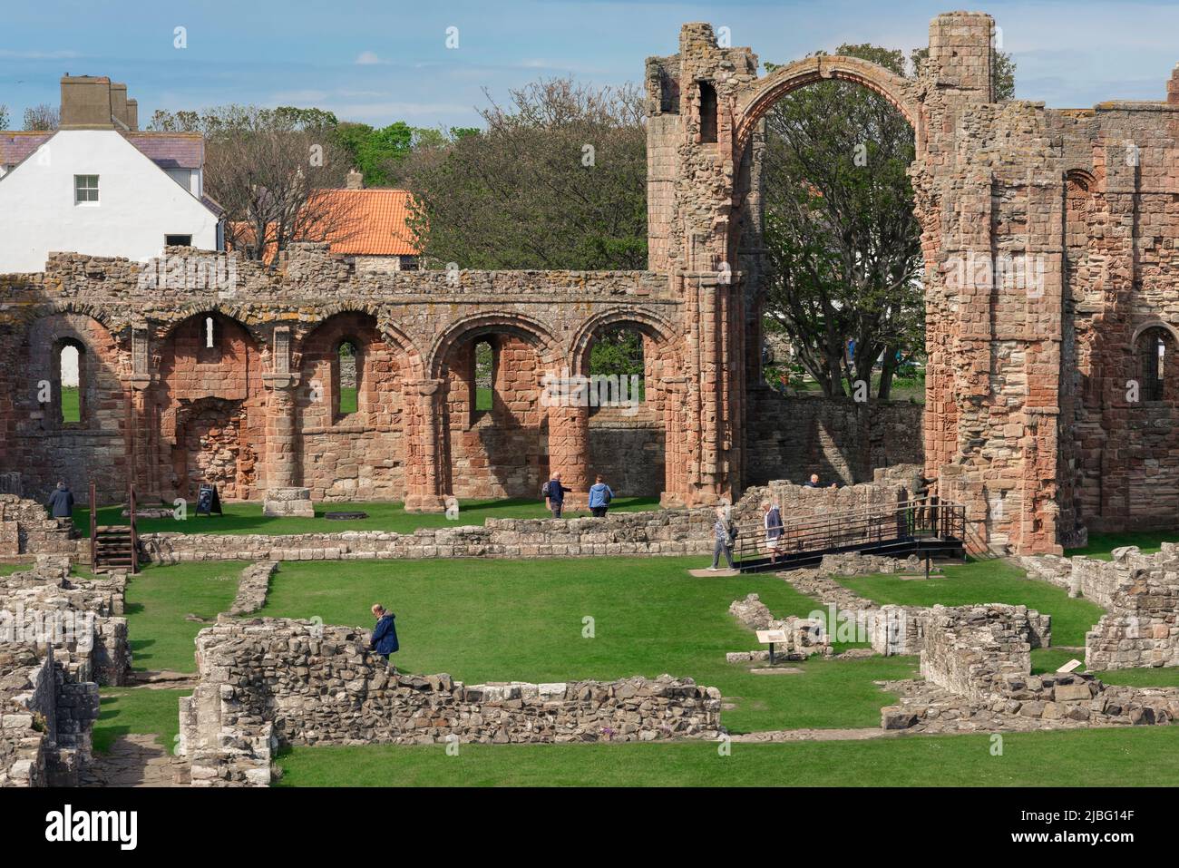 Lindisfarne Priory, view in spring of the ruined structure of Lindisfarne Priory showing the distinctive Rainbow Arch that once supported a tower, UK Stock Photo