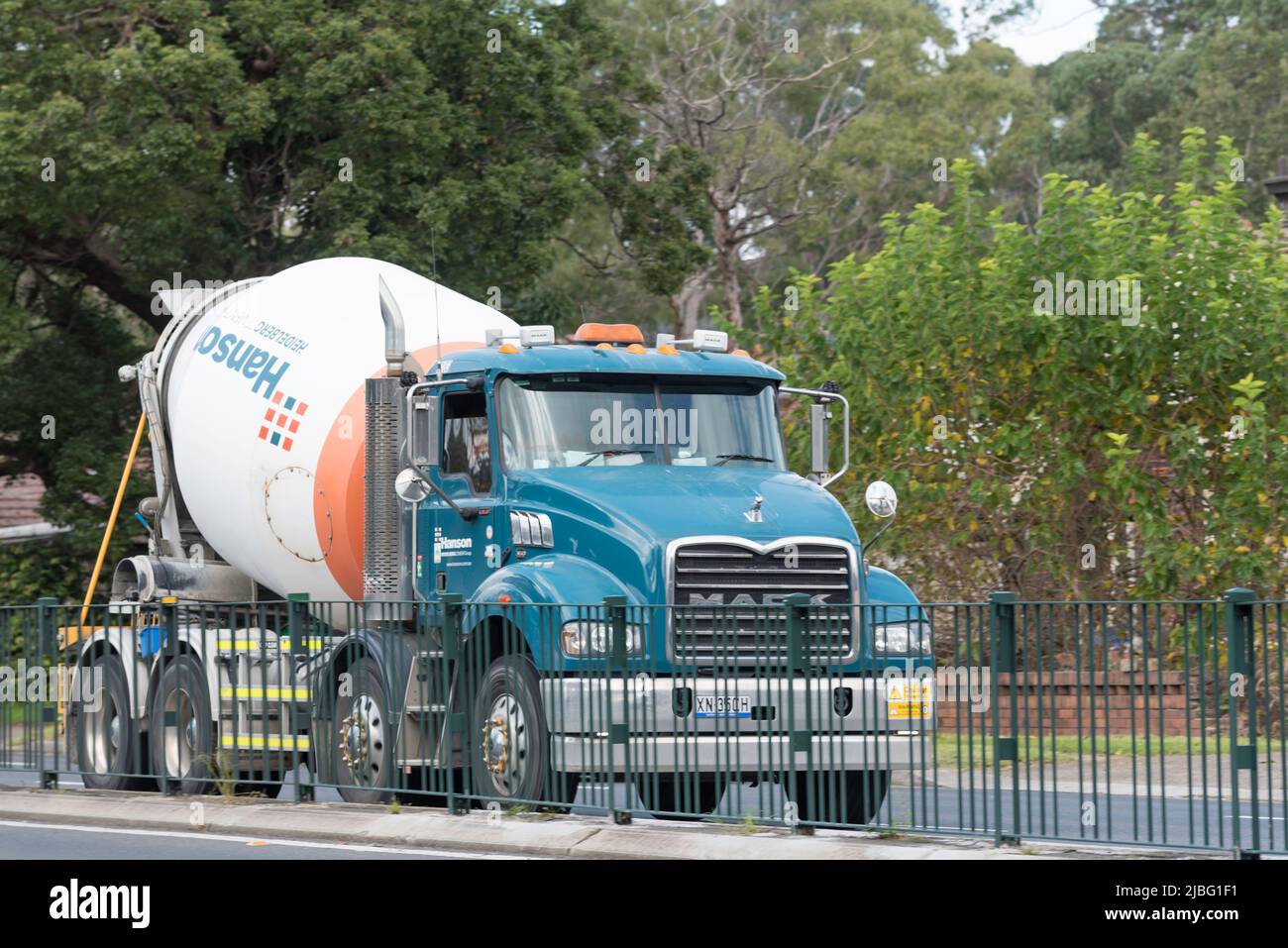 An image from in front and beside of a Hanson Concrete Mixer truck moving on a Pennant Hills Road, Normanhurst in Sydney, Australia Stock Photo