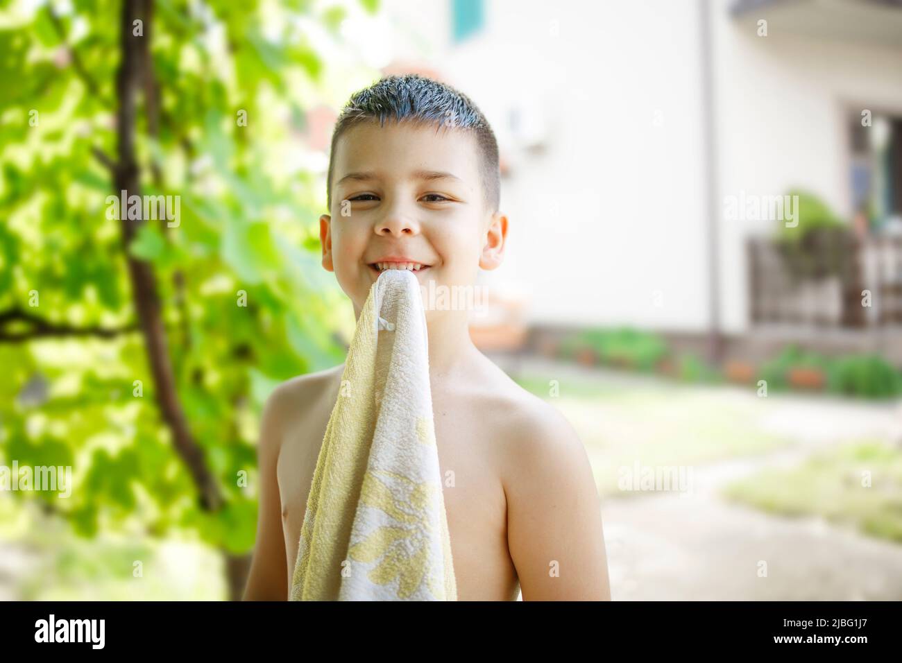 Young boy goofing around with a towel on a hot summer day Stock Photo