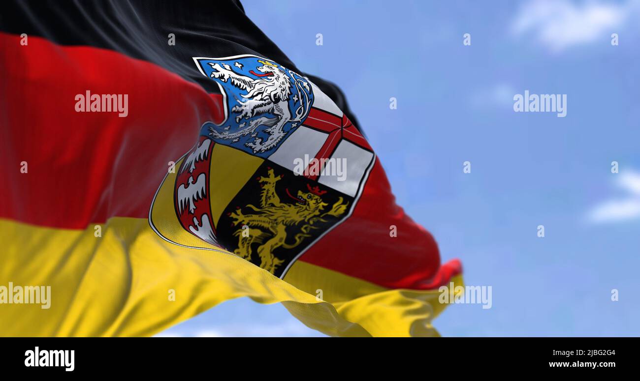 The flag of Saarland waving in the wind on a clear day. Saarland is a German state (Land) situated in southwestern Germany Stock Photo