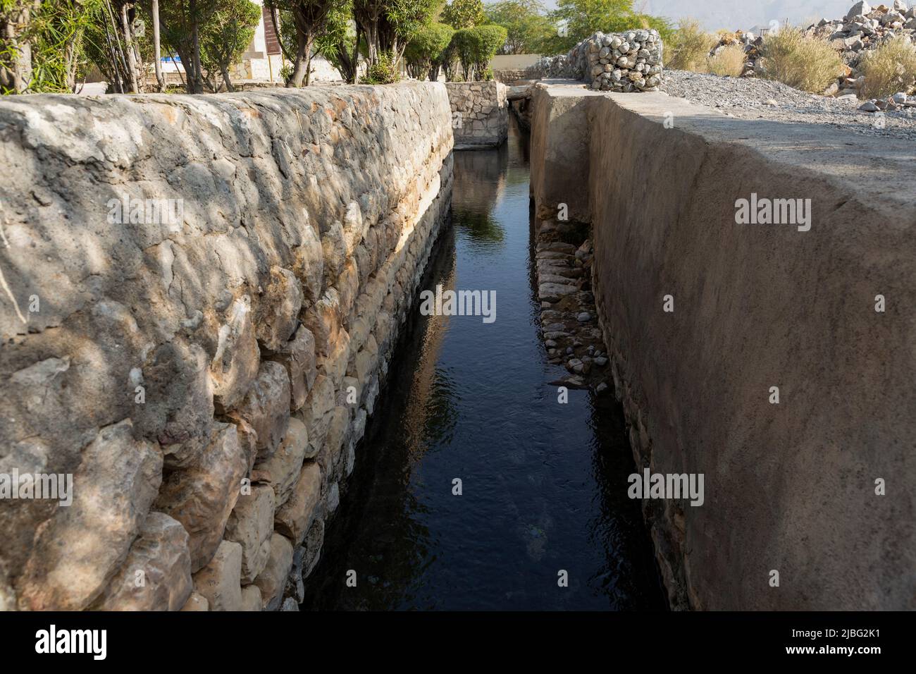 A stone-lined water channel from Falaj Daris in Nizwa, Oman, showcasing ...