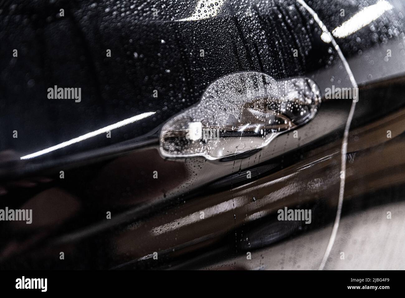 Car detailing technician applying transparent ppf foil Stock Photo