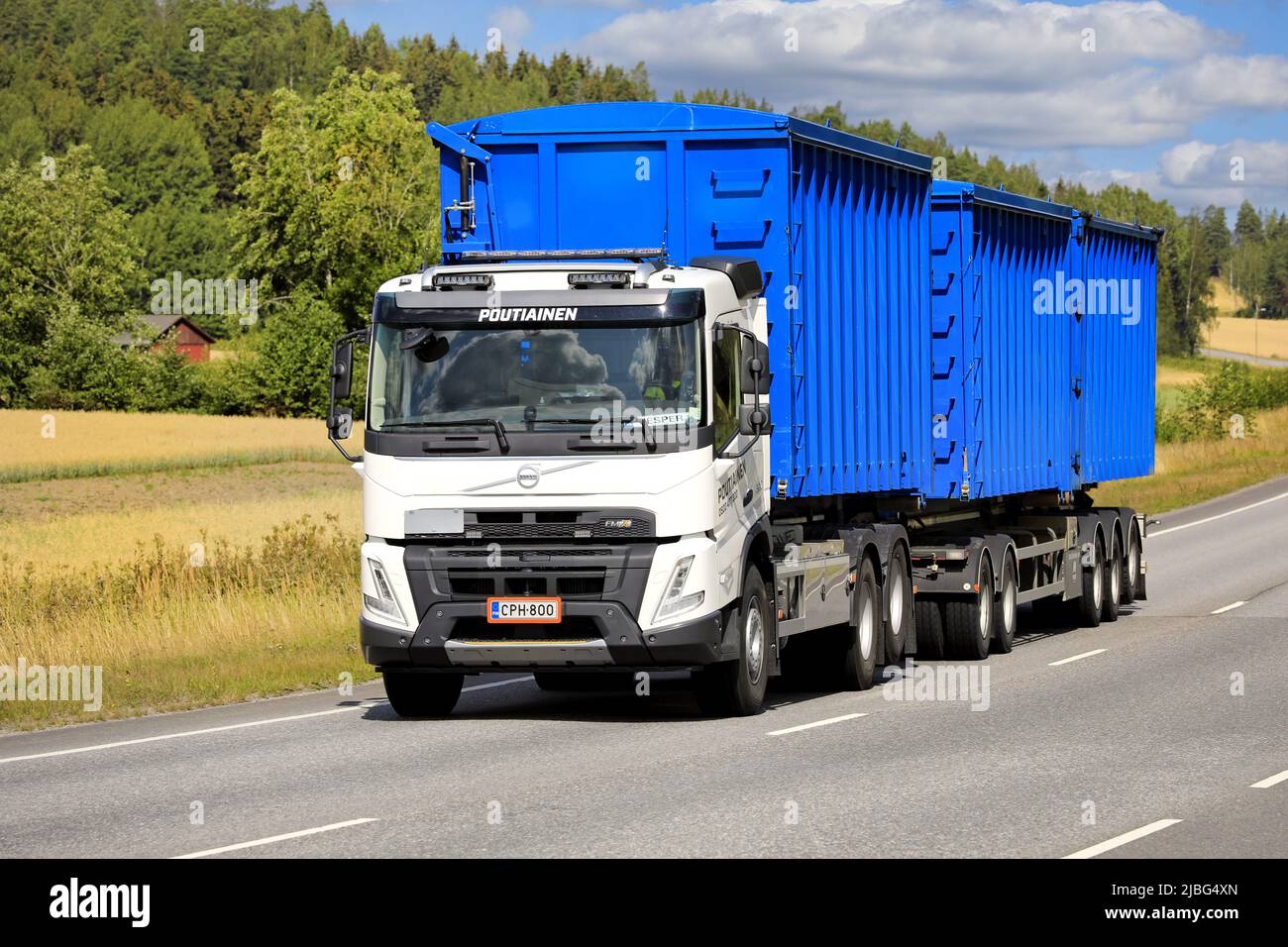 White Volvo FMX truck Martti Poutiainen Oy transports containers for environmental services along highway 52. Salo, Finland. August 11, 2021. Stock Photo
