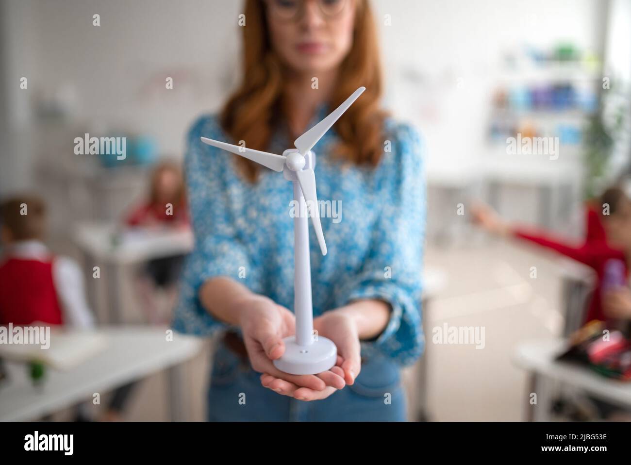 Close up for elementary school teacher holding model of wind turbine and learning kids about eco-friendly forms of renewable energy Stock Photo