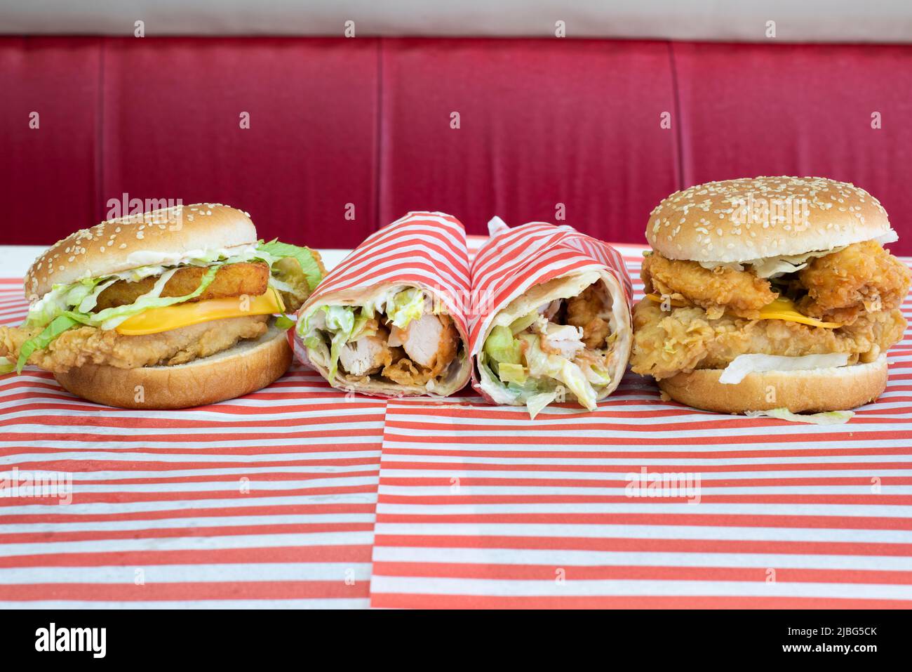 Yorkshire, UK – 18 March 2019: Two delicious variations of the southern fried chicken burger and a chicken strips wrap from Dixy Chicken, Doncaster Stock Photo