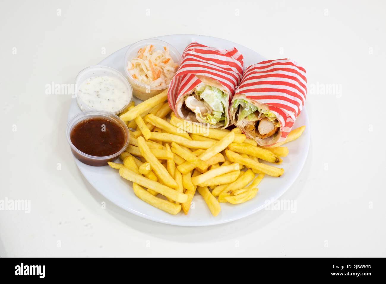 Yorkshire, UK – 18 March 2019: delicious crispy chicken strips wrap served with chips, sides and salad at Dixy Chicken, Doncaster Stock Photo
