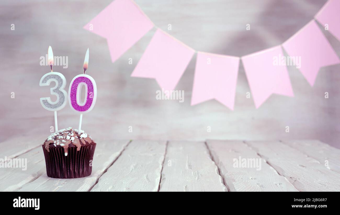 Birthday number. Festive background for a girl or woman with a muffin and  candles burning pink in pastel colors with decorations for any holiday  Stock Photo - Alamy