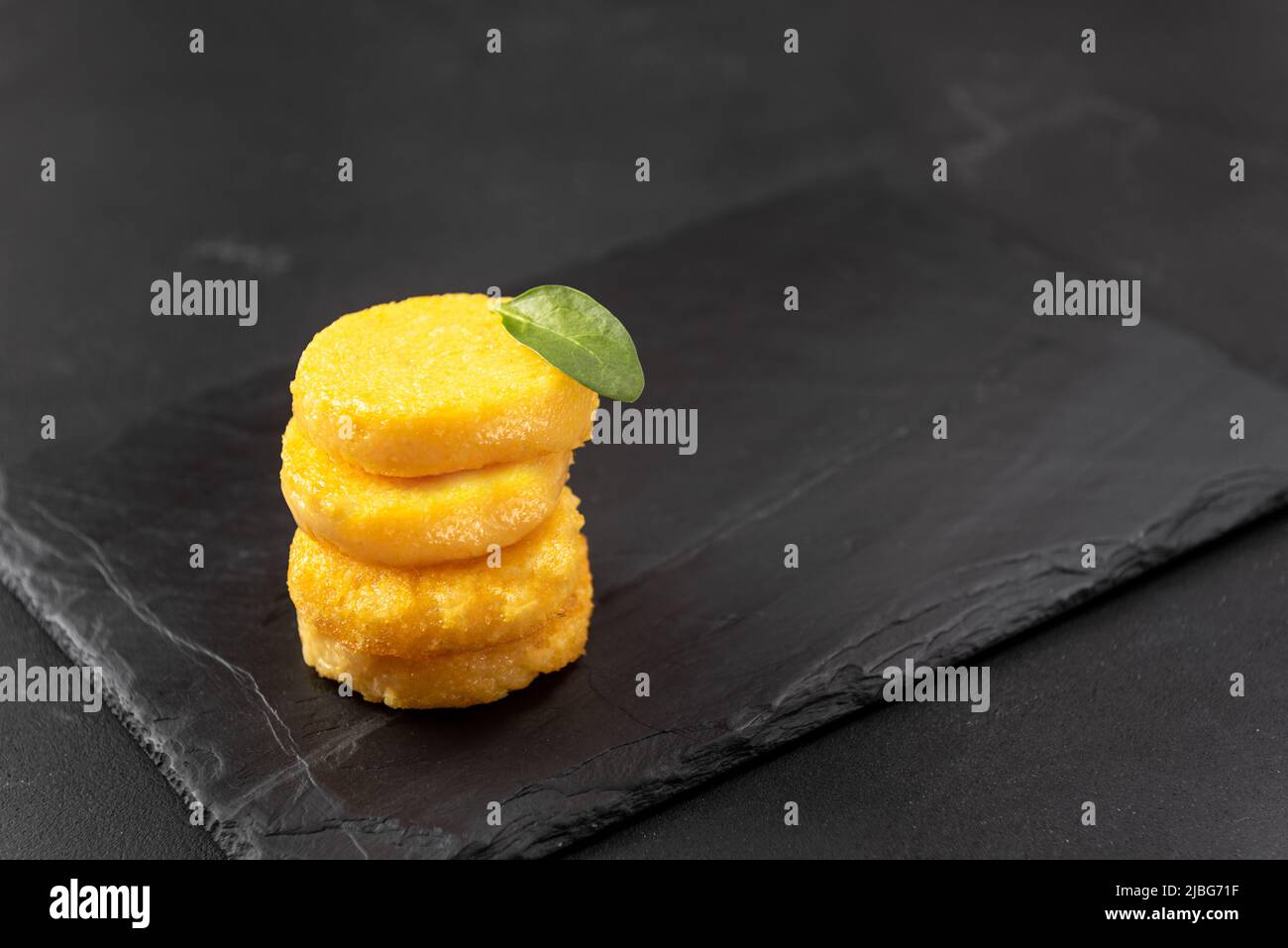A Stack of Fried Polenta Discs, copy space for your text on the dark