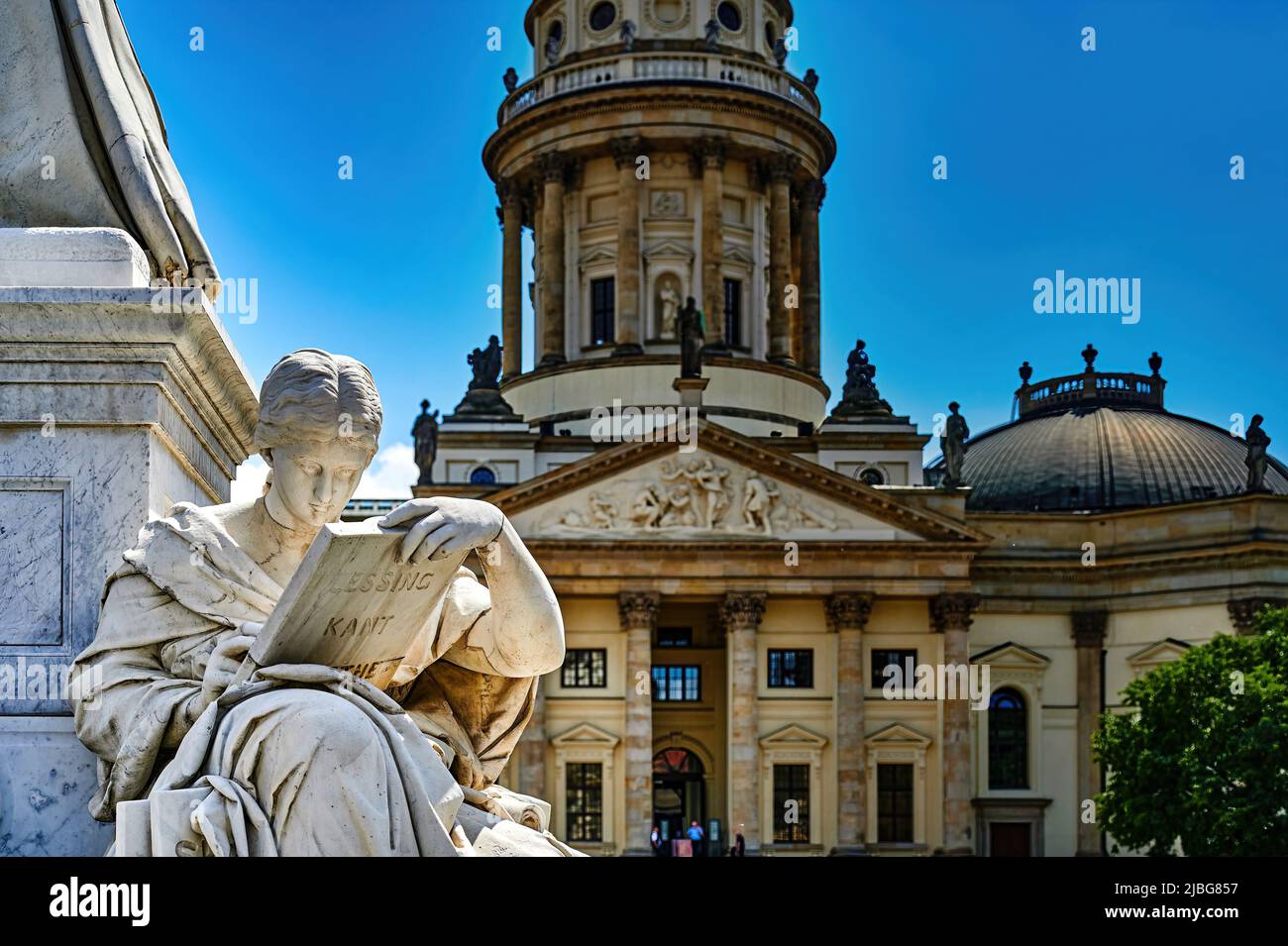 View to a statue of the Schiller monument and the unfocussed German Cathedral in the background. Stock Photo