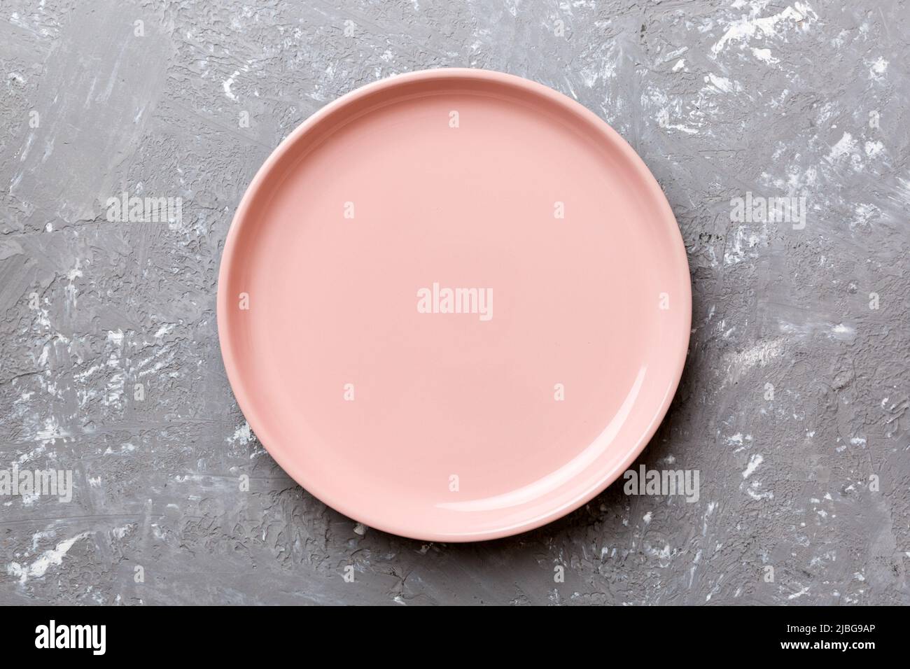 Top view of empty pink plate on cement background. Empty space for your ...