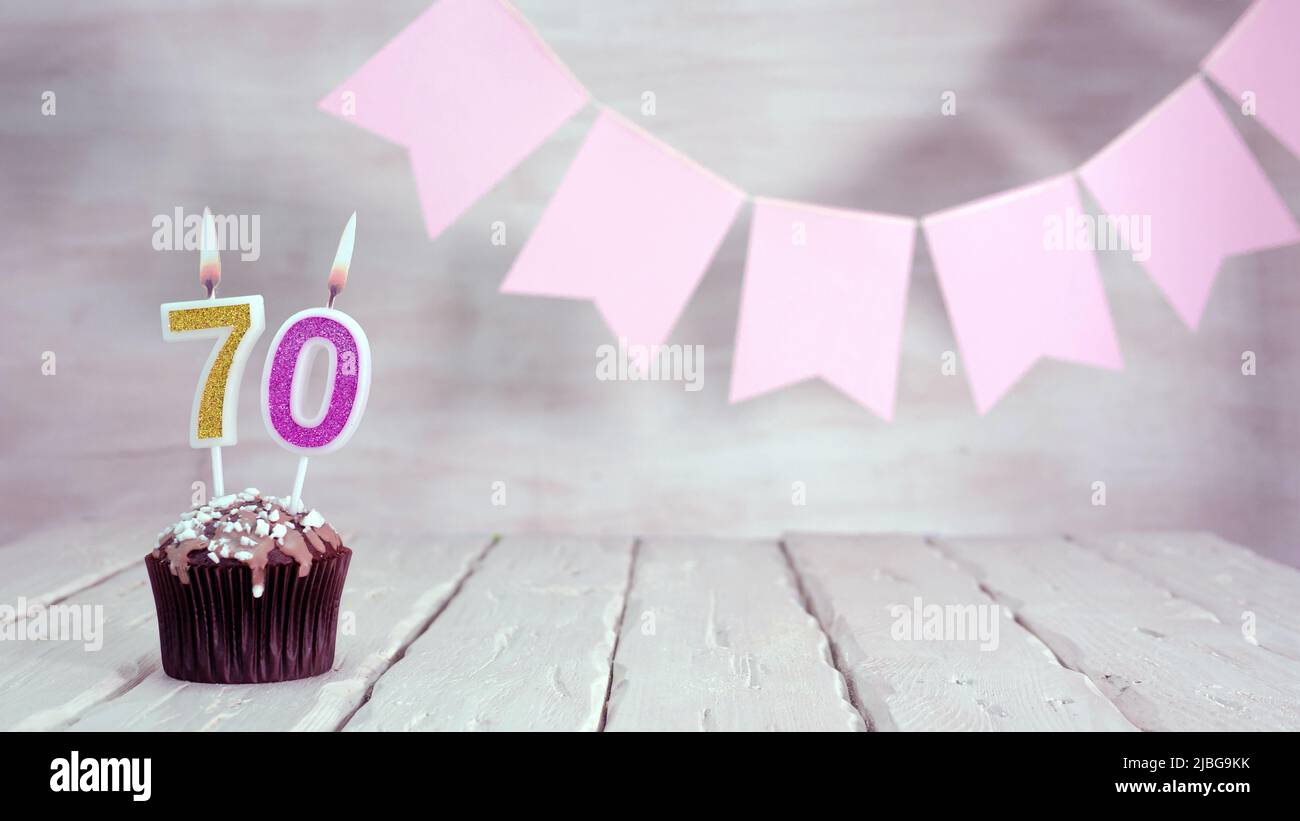 Birthday number. Festive background for a girl or woman with a muffin and candles burning pink in pastel colors with decorations for any holiday, Stock Photo