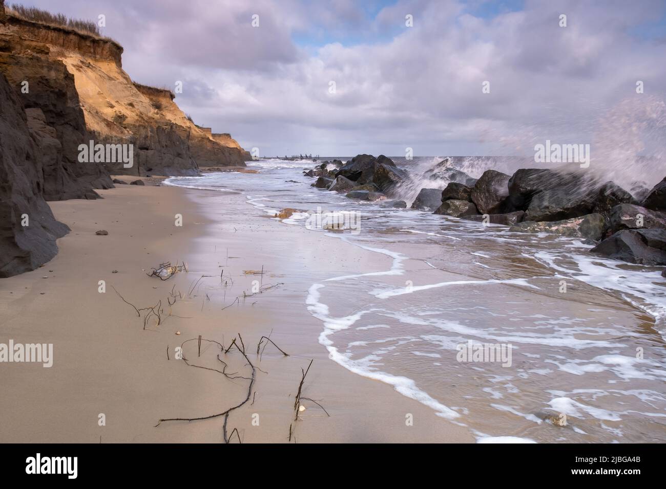 waves breaking over the sea defences at Happisburgh on the Norfolk coast Stock Photo