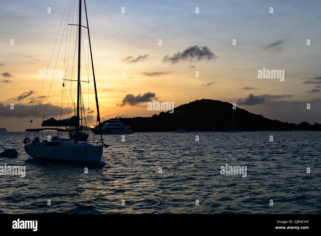 Sonnenuntergang  in den Tobago Cays - Saint Vincent and The Grenadines mit Segelyacht im Hintergrund Stock Photo