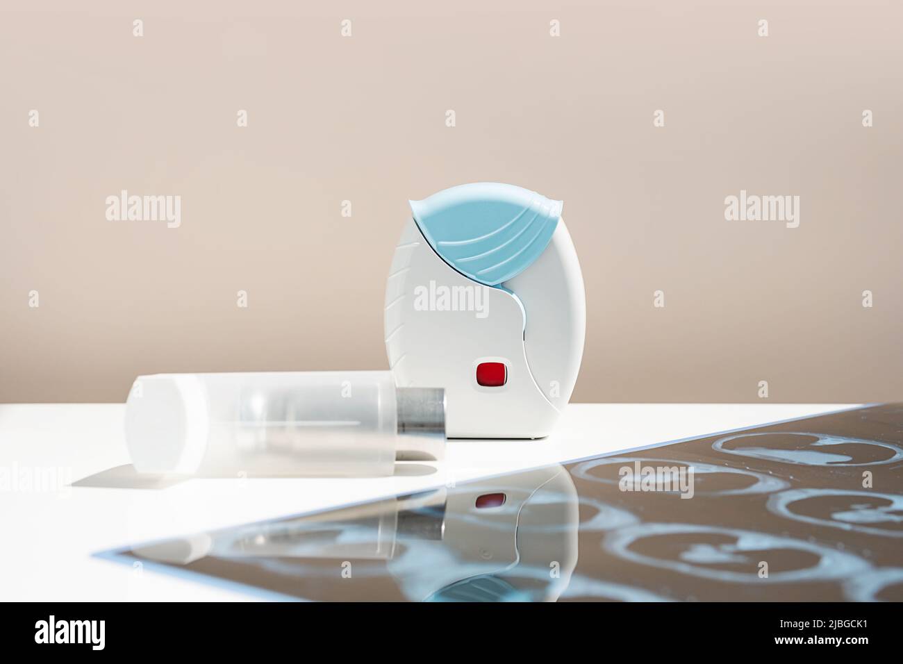 Some asthma inhalers and CT scan of the lungs on white table. Aerosol for inhalation for treat lung inflammation and prevent asthma attack. Stock Photo