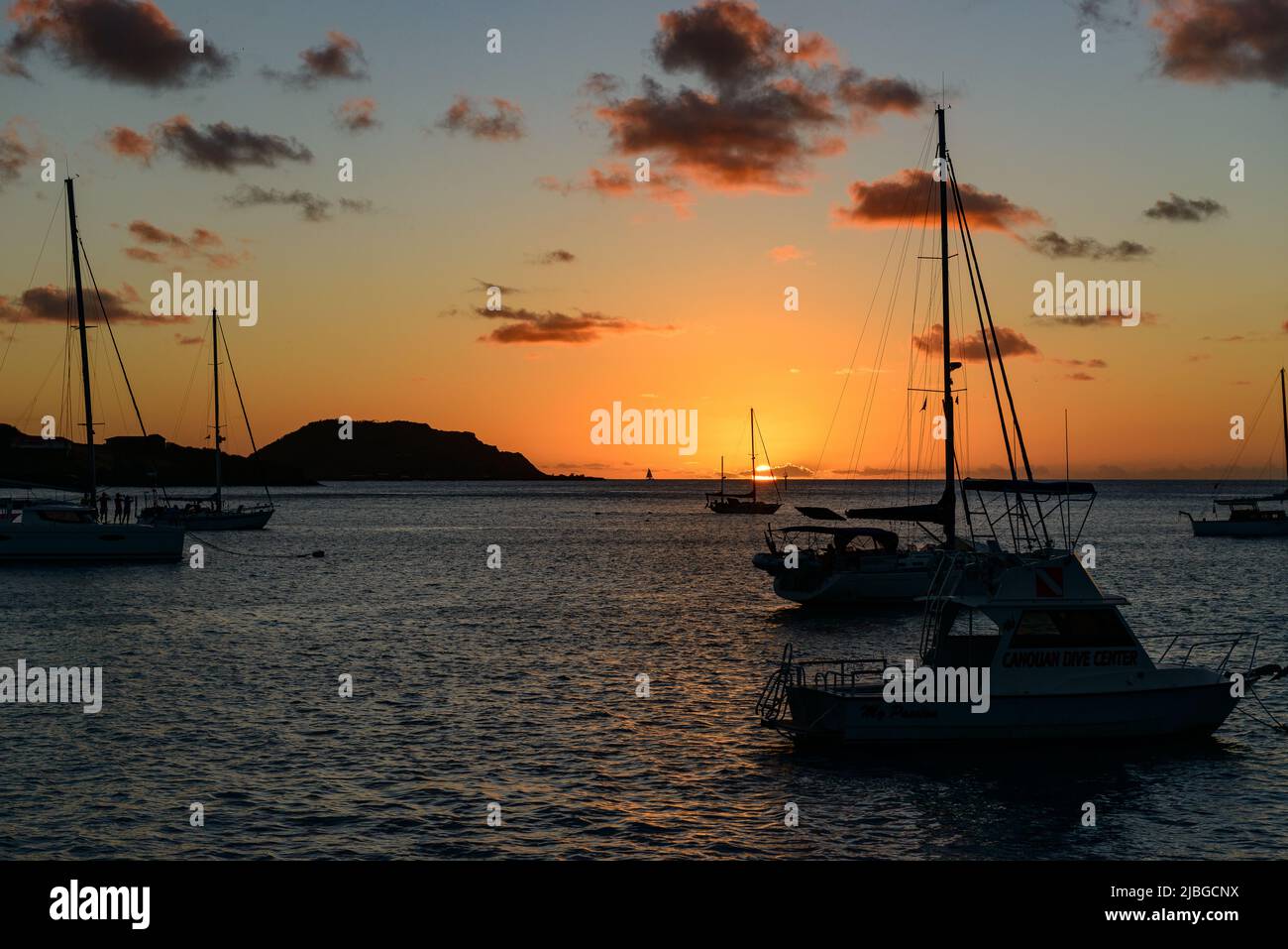 Sonnenuntergang  bei Canouan - Saint Vincent and The Grenadines mit Segelyacht im Hintergrund Stock Photo