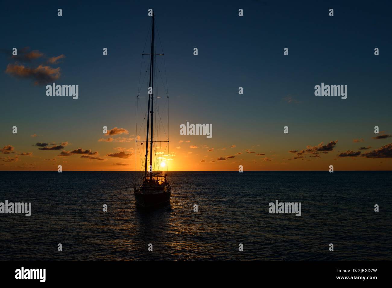 Sonnenuntergang  bei Mustique -  Saint Vincent and The Grenadines mit Segelyacht im Hintergrund Stock Photo