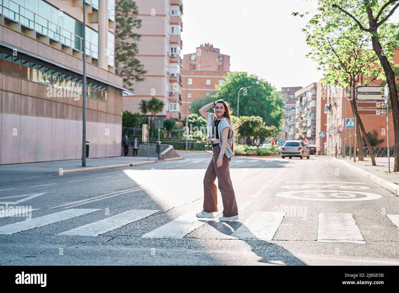 teenage woman crossing the street at a pedestrian crossing Stock Photo ...