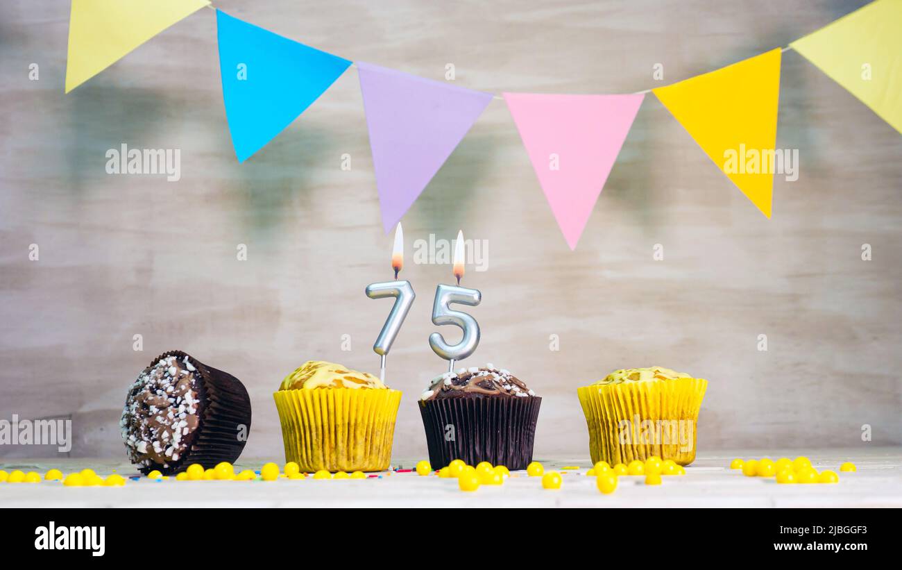 Birthday background with number. Beautiful birthday card with colorful garlands, a muffin with a candle burning copyspace. Stock Photo