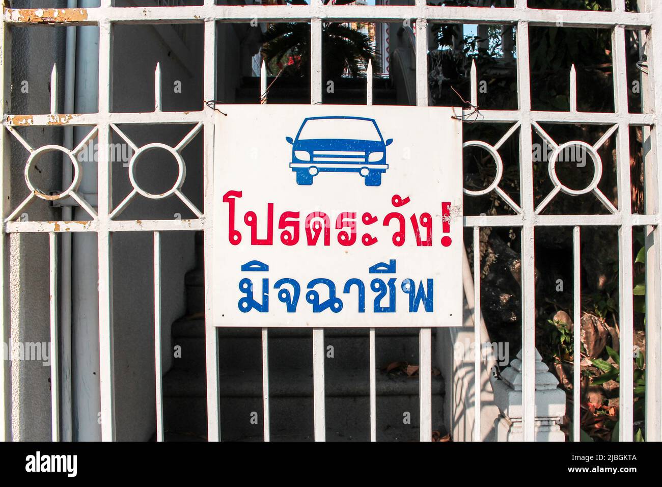 The image of warn car sign in Thai hanged on the gate in the site of building. Translation : please be careful of criminal. Stock Photo