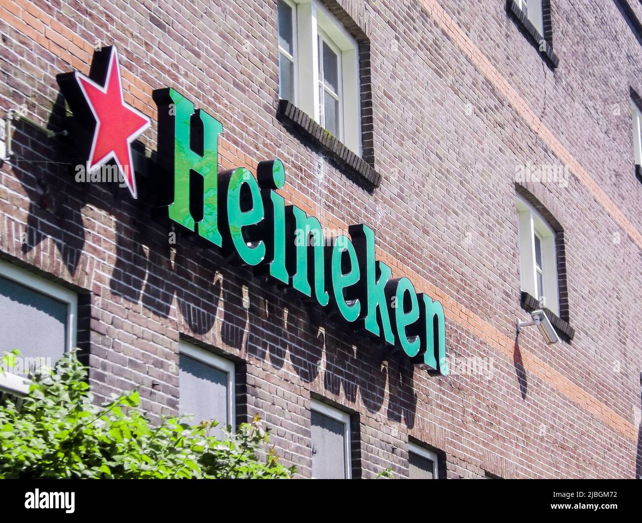 Amsterdam, Netherlands - July 6, 2011 : The close up image of Heineken logo hanged on brick wall at Heineken Experience, Amsterdam, Netherlands. Stock Photo