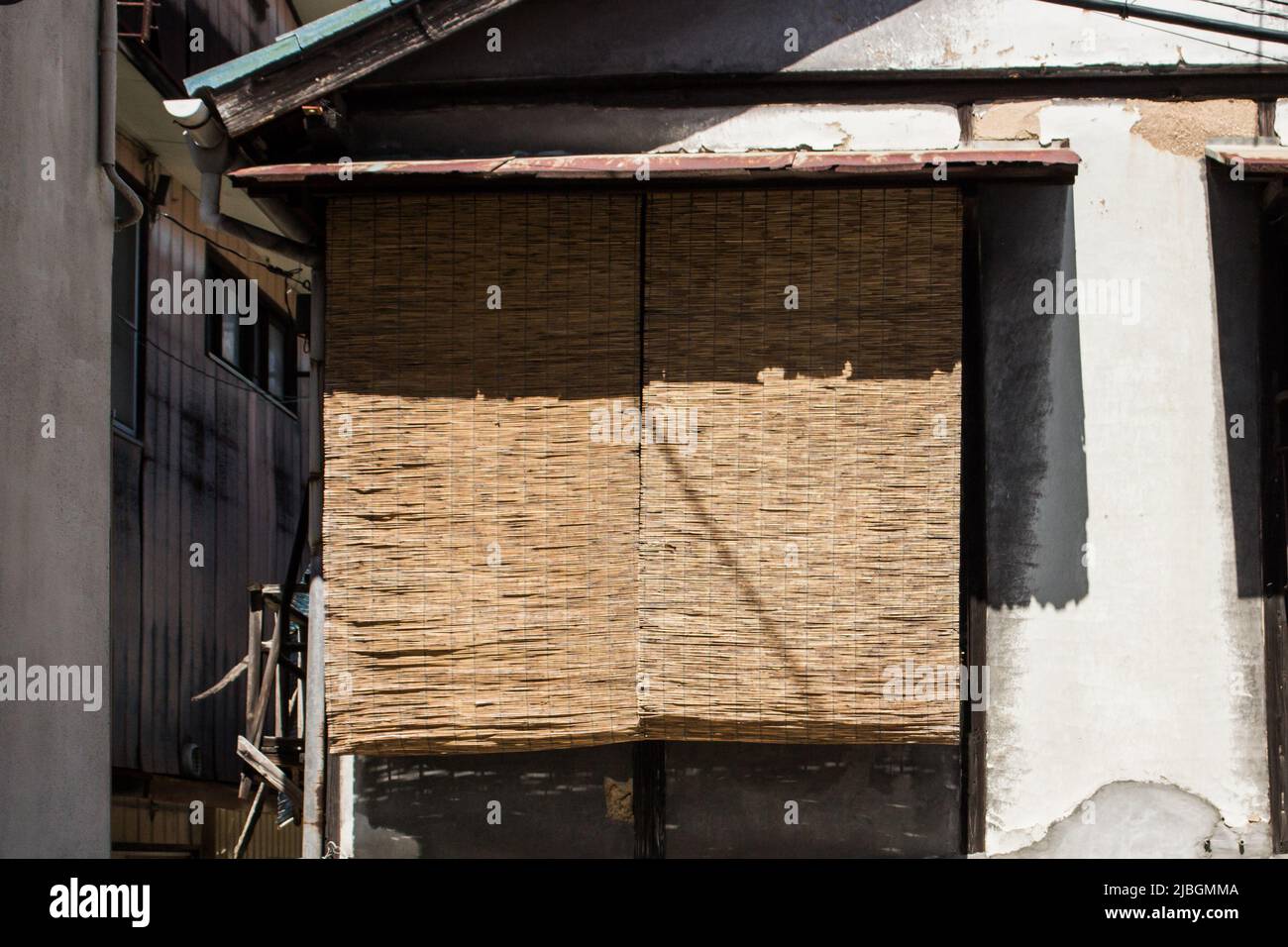 Old house with Japanese traditional blind Sudare, hanging on window to block sunlight. Sudare blind is made by knitting strips of bamboo string. Stock Photo