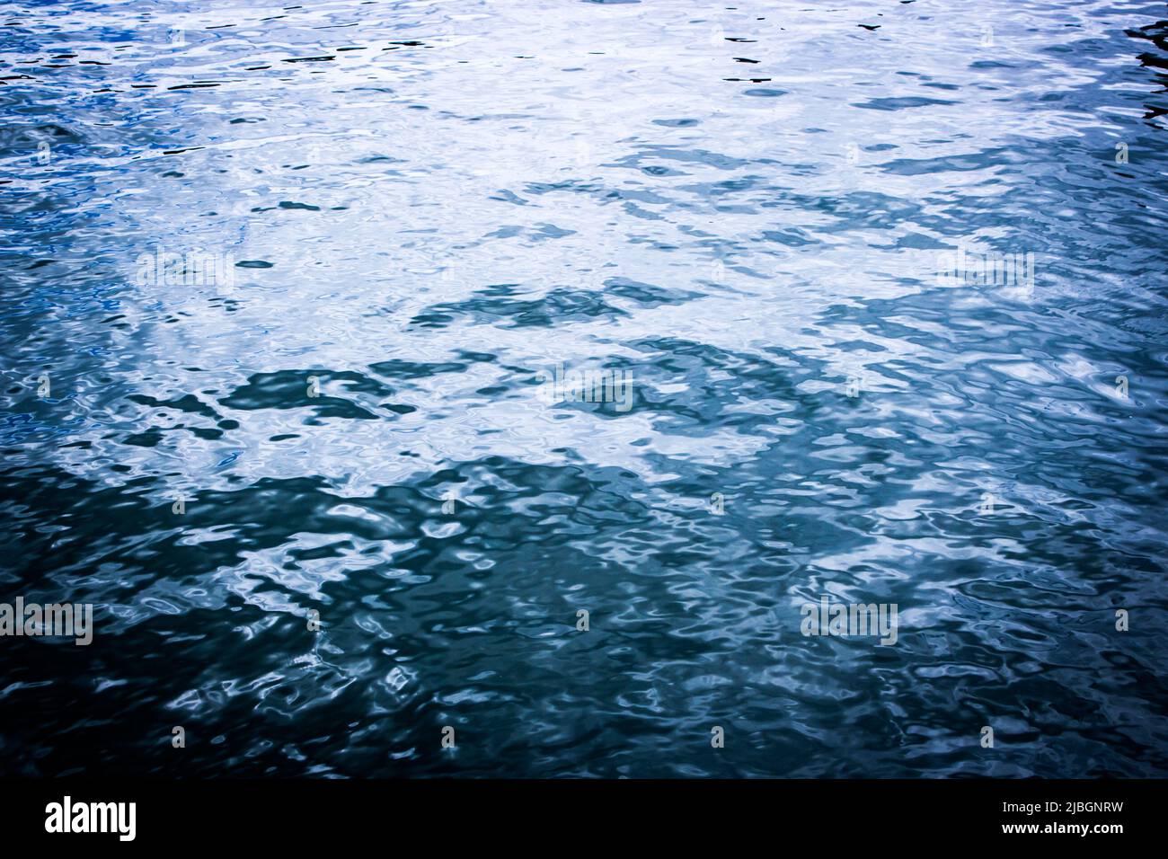 Abstract navy blue coloured water surface background with vibrant. Stock Photo