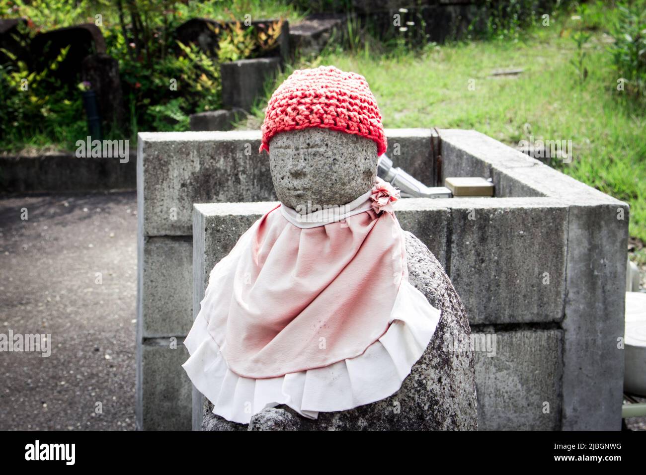 Unknown Jizo image wearing apron and knit hat by unknown sculptor, Nagoya, Japan. Stock Photo