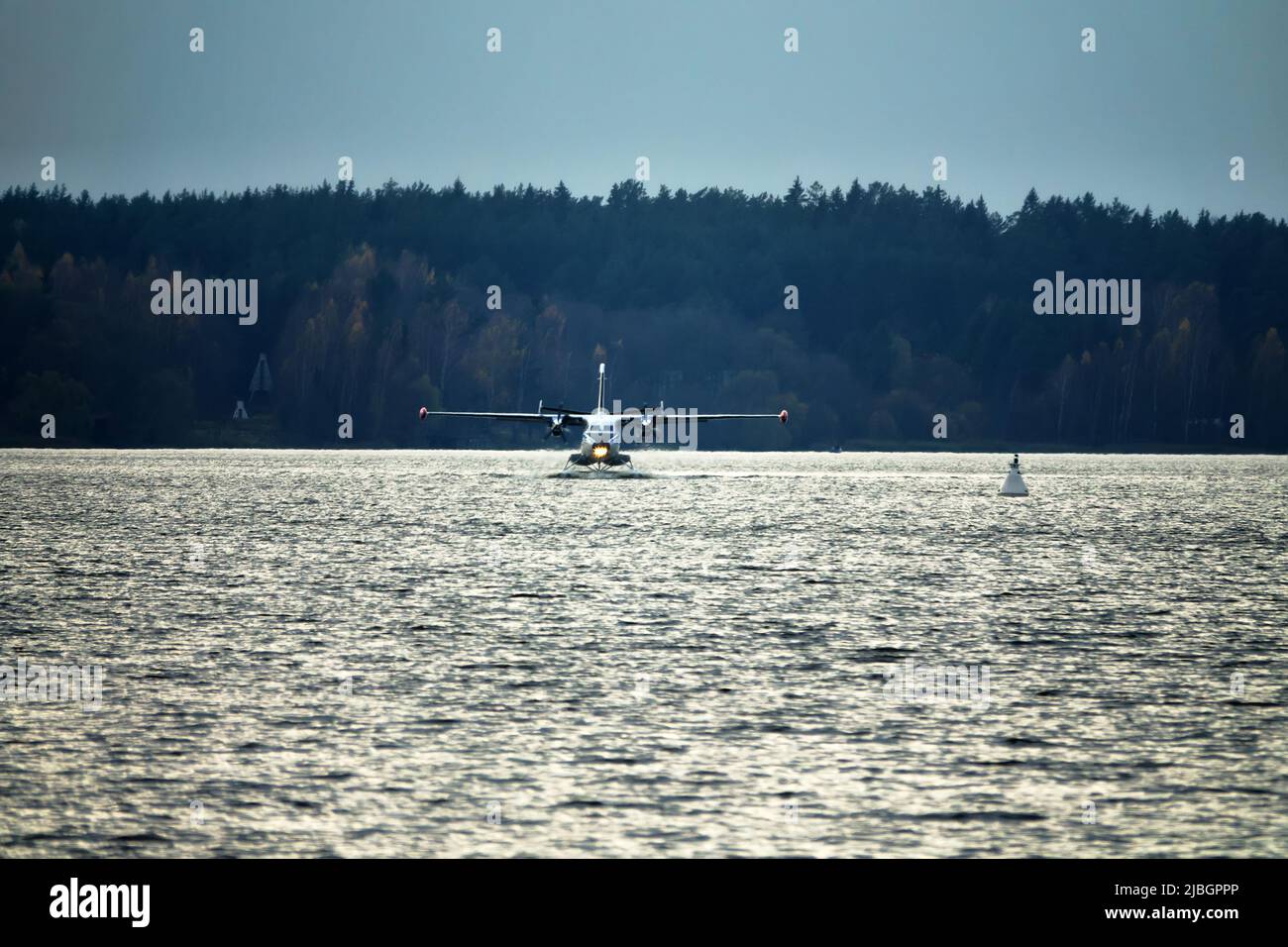 The Twinengine seaplane a seaplane rises from water, from the forest
