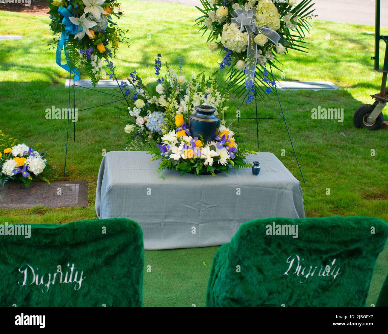 Cremation urn at funeral ceremony with floral arrangement Stock Photo