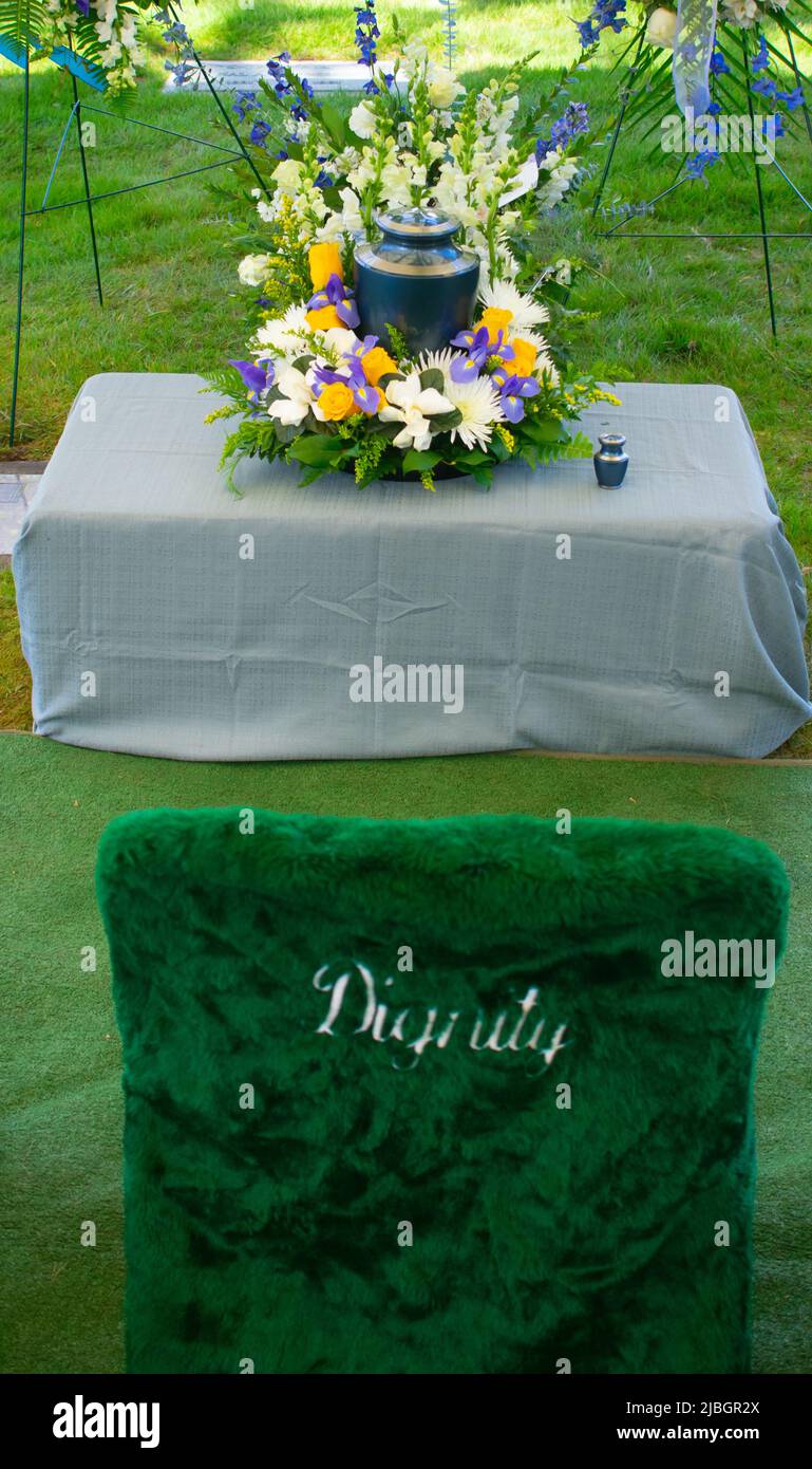 Cremation urn at funeral ceremony with floral arrangement Stock Photo