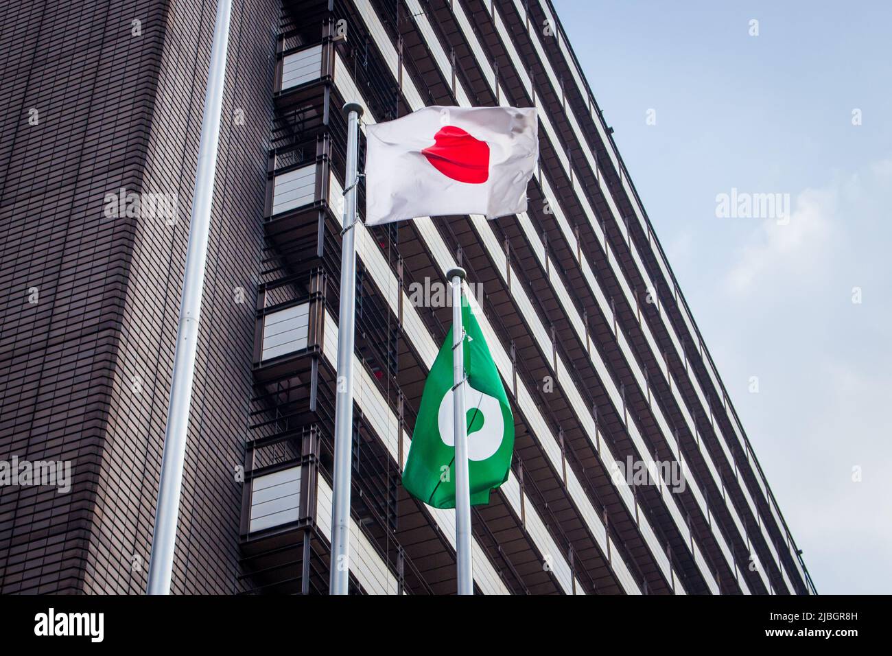 Japanese flag and Kumamoto city flag which are attached to flag poles. Kumamoto city flag was defined in 1969. fluttering in the breeze Stock Photo
