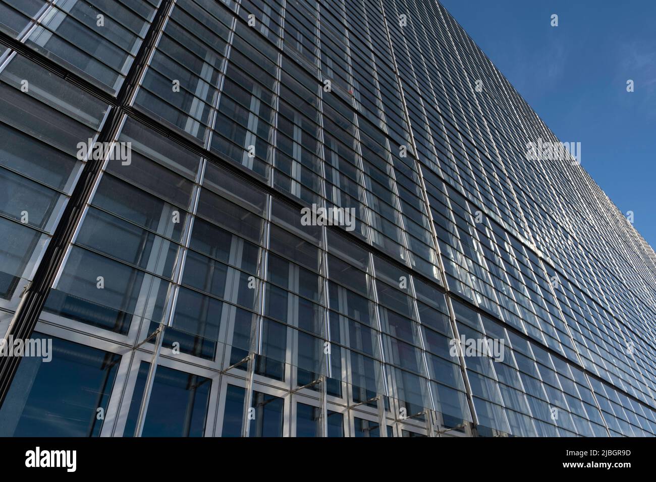 Modern office building with glass facade on a clear blue sky background ...