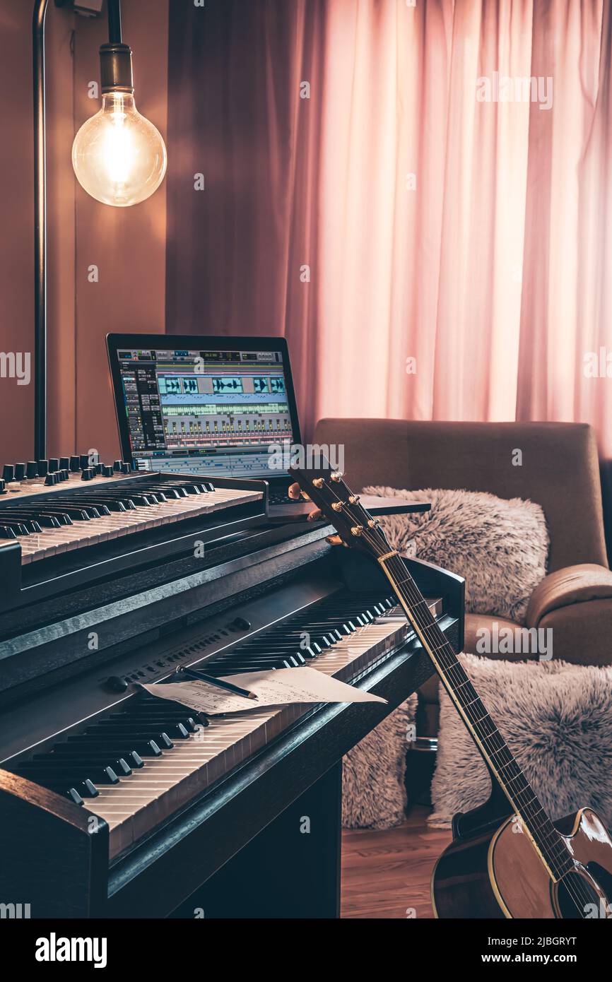 Electronic piano and guitar in room interior. Stock Photo