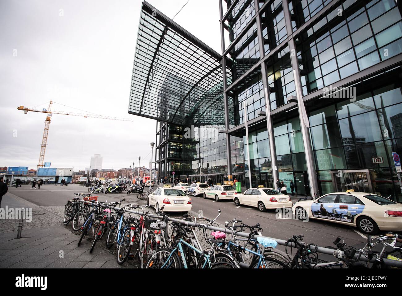 Main entrance of Berlin Hauptbahnhof station. Hauptbahnhof is the main railway station in Berlin. There are taxes and parked bicycles in image. Stock Photo