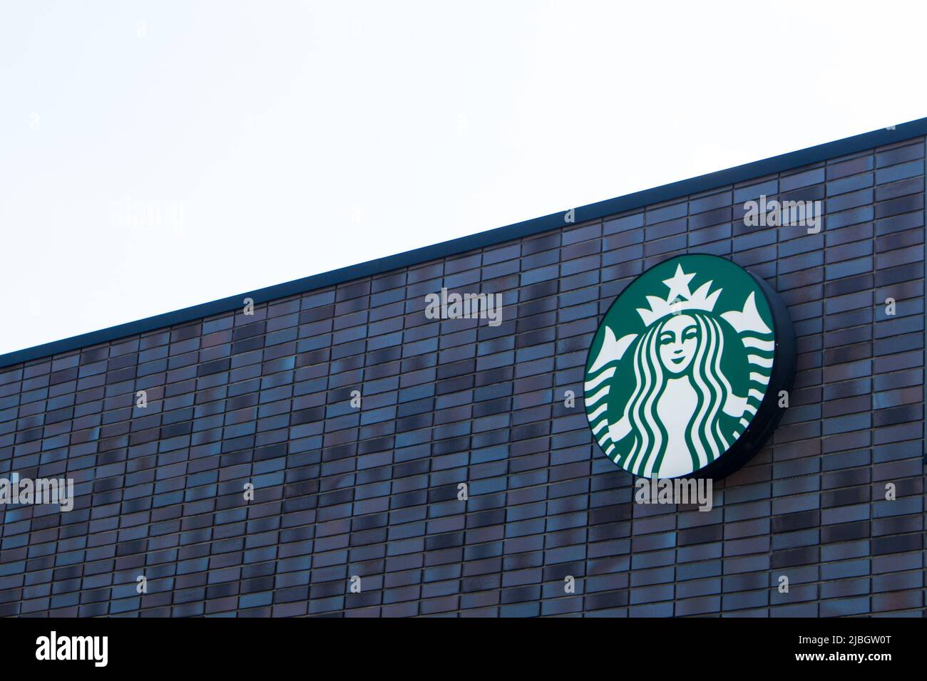 Starbucks Coffee logo on the store wall. The first Starbucks location outside North America opened in Tokyo, Japan, in 1996 Stock Photo