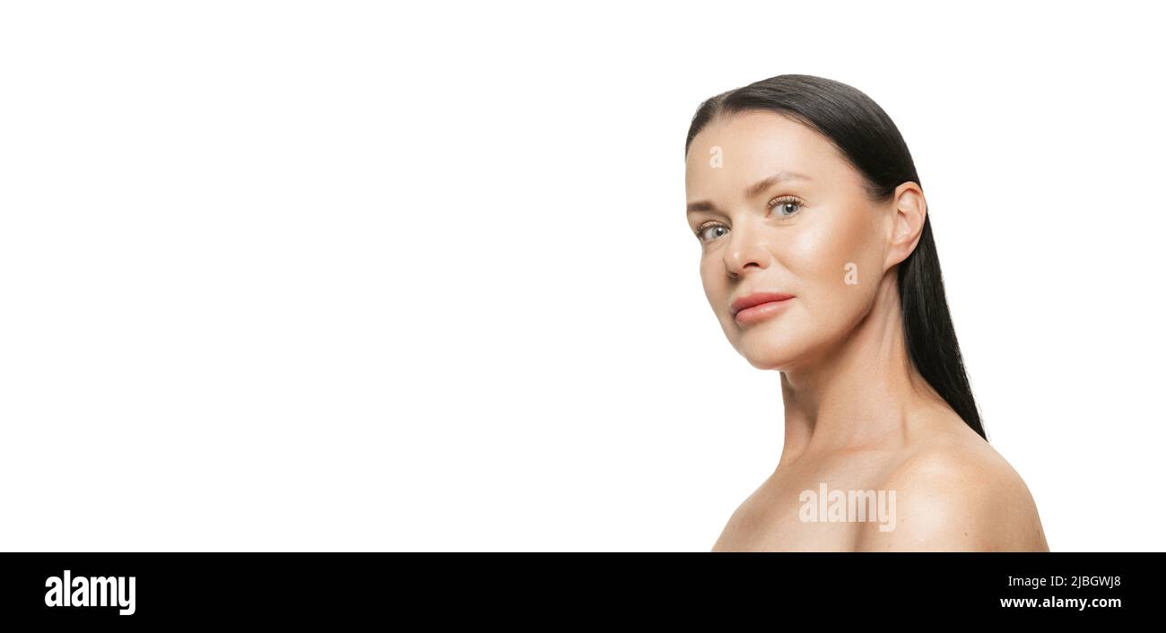Beauty portrait of happy 44 years old beautiful woman with well-kept skin on white background. Cosmetics, spa, age-related changes, face lifting and Stock Photo
