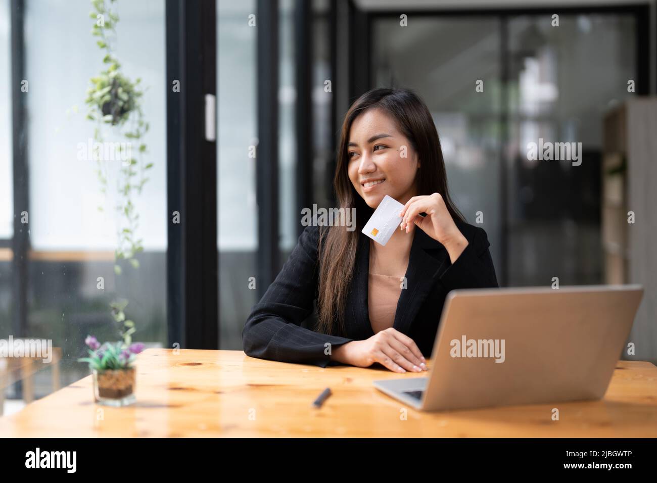 Young asian woman making laptop for mobile banking, purchasing online shopping with credit card. Stock Photo