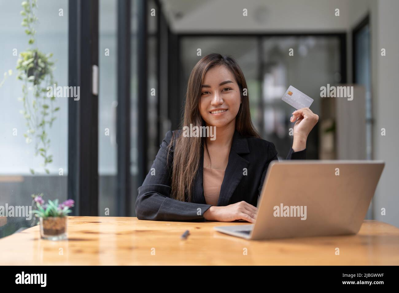 Young asian woman making laptop for mobile banking, purchasing online shopping with credit card. Stock Photo