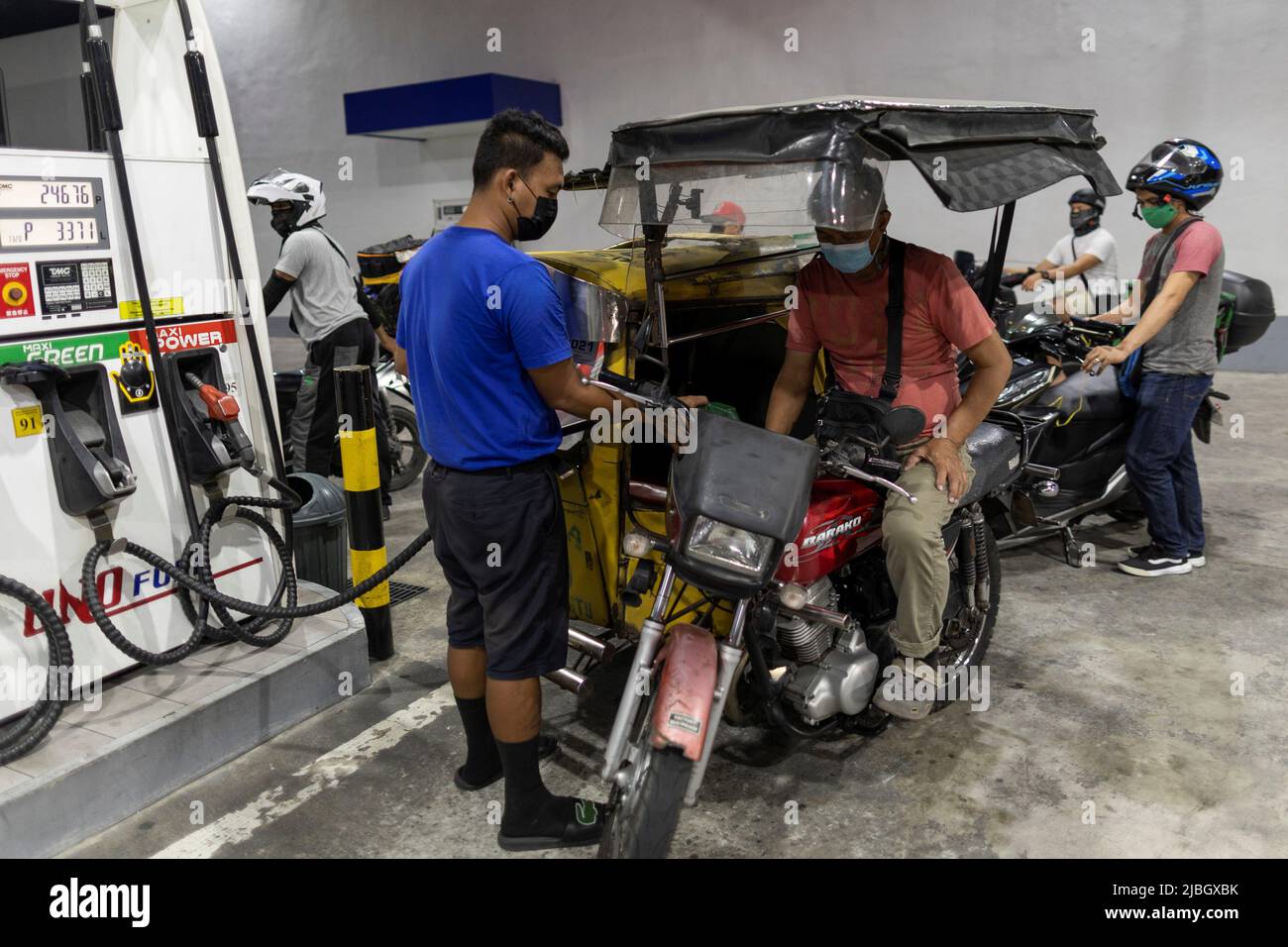 Motorists queue at a gas station a day before an oil price hike, in