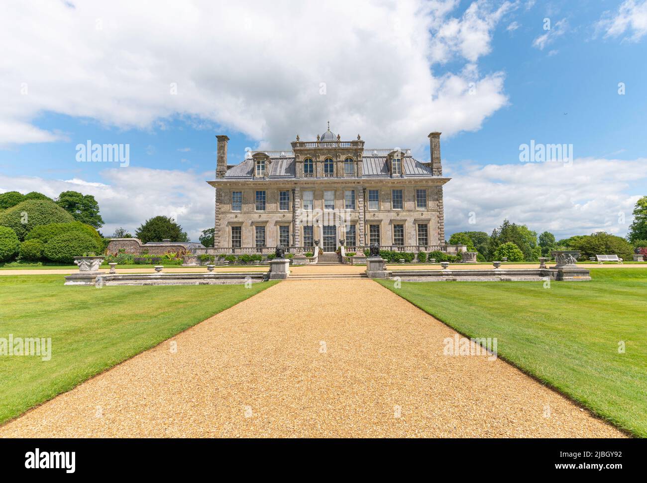 Kingston Lacy Country House with short grass and gravel path on a sunny day with white clouds.  Wimborne, Dorset, England. Stock Photo