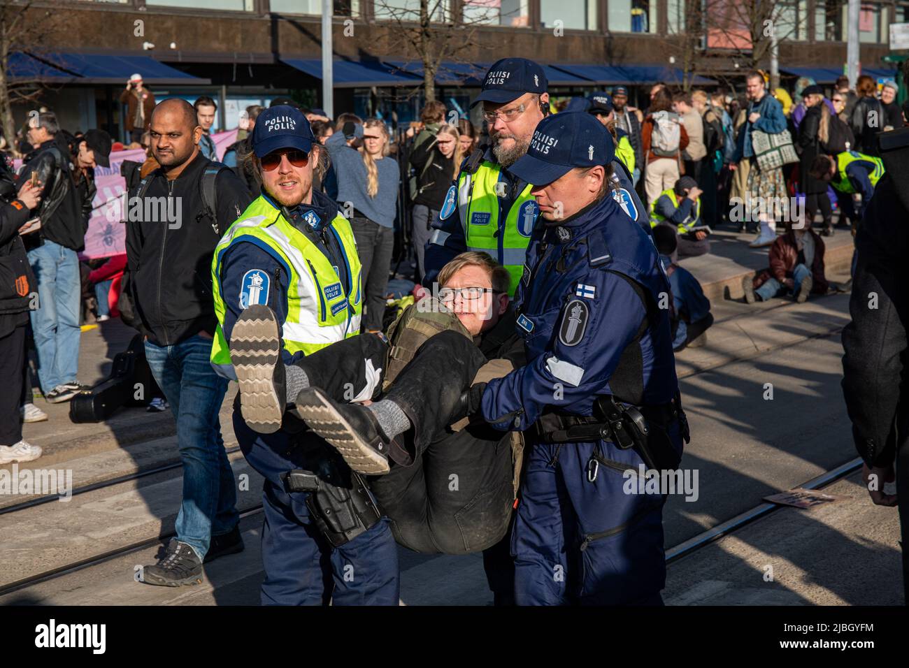 Protester being arrested and carried away by police officers at Elokapina's street blocking demonstration in Mannerheimintie, Helsinki, Finland. Stock Photo