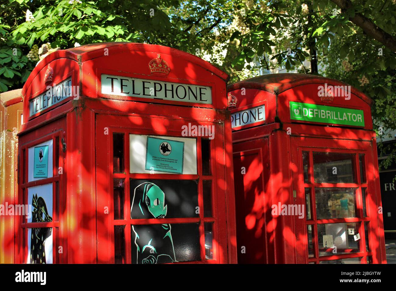 Red telephone box converted to hold defibrillator with the Adopt a Kiosk programme (Cheltenham, England) Stock Photo