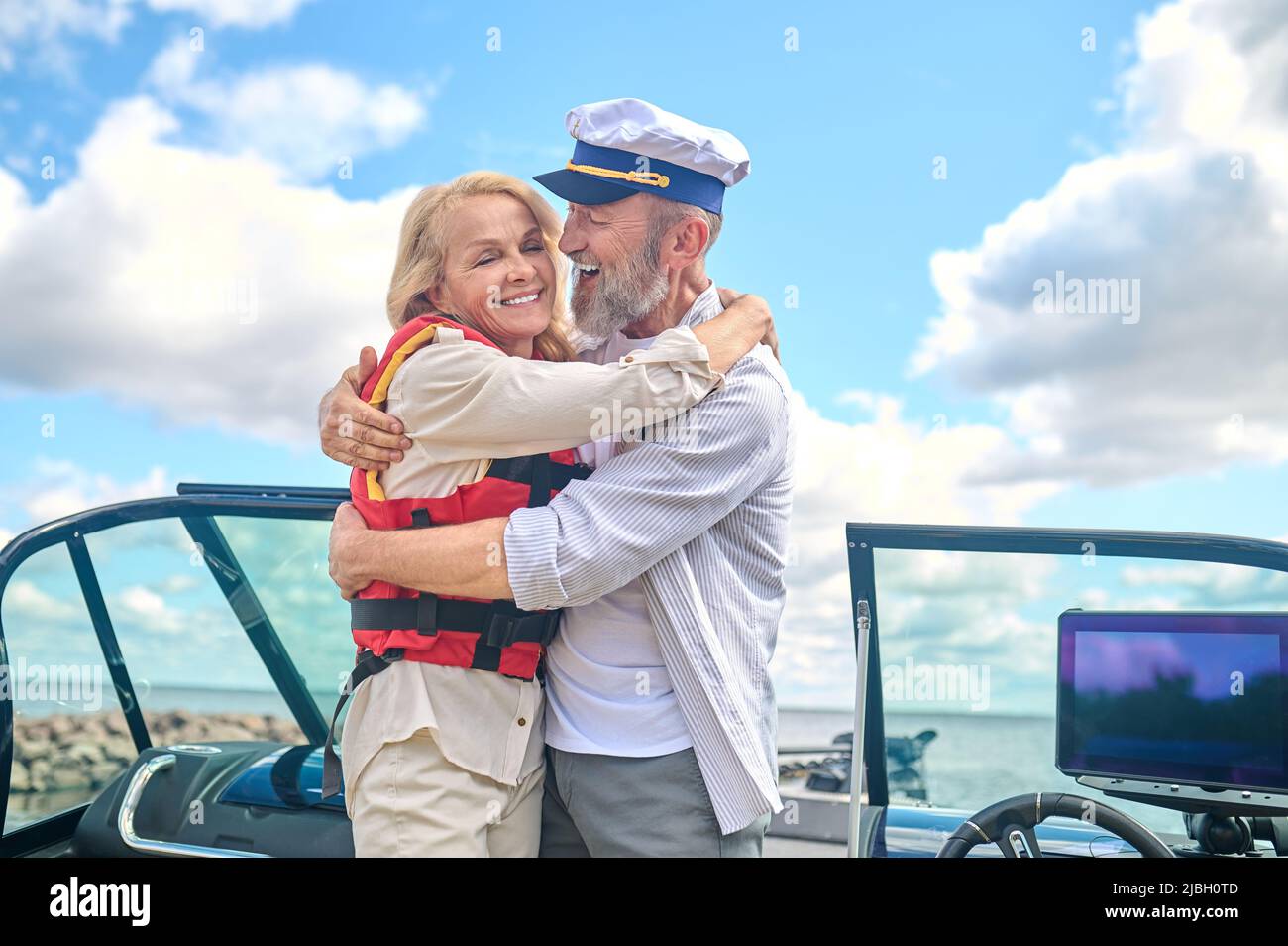 A man and a woman standing on a boat and hugging each other Stock Photo